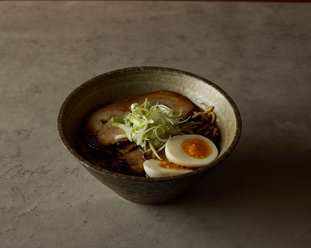 Close-up of a ramen bowl with noodles and garnishes